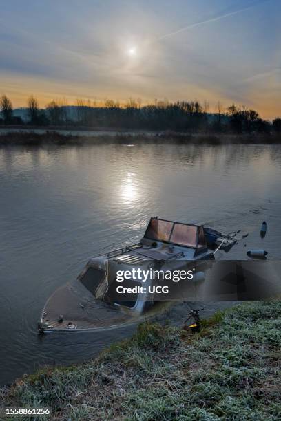 Sunken pleasure boat investigated on the Thames at Abingdon, winter sunrise.