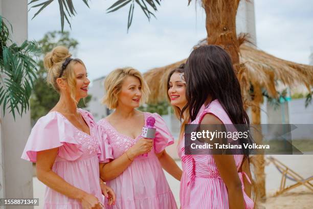 fierce and fabulous: women empowerment shines as diverse group enjoys a microphone moment at a pink doll cinema party - your moment is waiting world premiere stock pictures, royalty-free photos & images