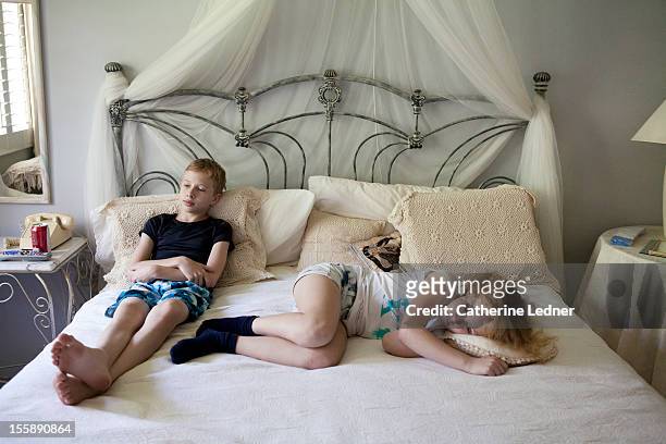 a young boy and girl relaxing on a bed - 13 year old girls in shorts stock pictures, royalty-free photos & images