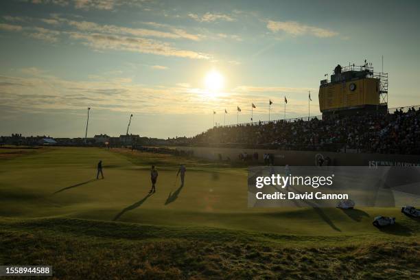 The group of Justin Thomas, Tony Finau and Viktor Hovland on the green in the late evening light on the 18th hole during the first round of The 151st...