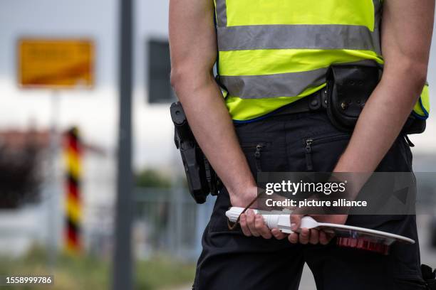 July 2023, Brandenburg, Frankfurt : A police officer with a ladle in his hands stands at the German-Polish border. More unauthorized entries were...