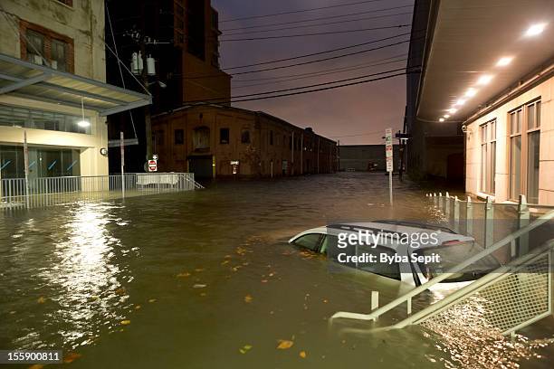 flooded car on an urban street - flood stockfoto's en -beelden