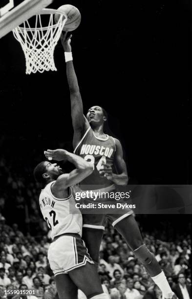 Hakeem Olajuwon of the Houston Rockets shoots the ball over Earvin Magic Johnson during an NBA Finals basketball game circa 1995 at the Forum in...