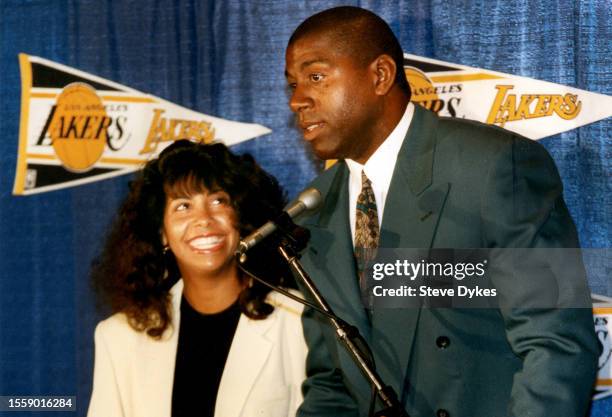 Earvin Magic Johnson of the Los Angeles Lakers speaks with the media as he is introduced as head coach during a press conference while his wife,...