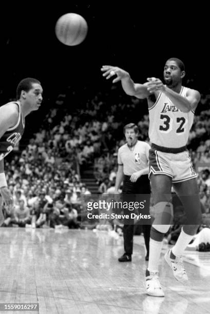 Earvin Magic Johnson of the Los Angeles Lakers passes the ball on Dennis Johnson of the Boston Celtics looks on during an NBA Finals basketball game...