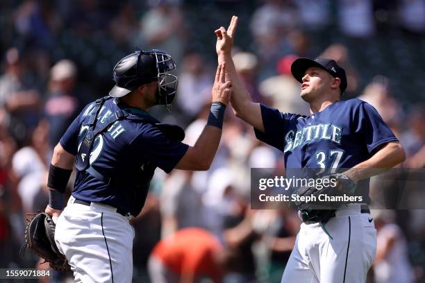 Cal Raleigh and Paul Sewald of the Seattle Mariners celebrate their 5-0 win against the Minnesota Twins at T-Mobile Park on July 20, 2023 in Seattle,...