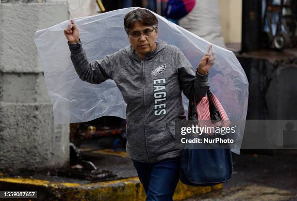 Woman holds a plastic sheet to cover herself from the rain on Tlahuac Avenue and Taxquena Avenue in Mexico City. This Thursday, on July 27 in Mexico...