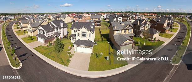 high angle view of suburban houses along a curving street - new pavement stock pictures, royalty-free photos & images