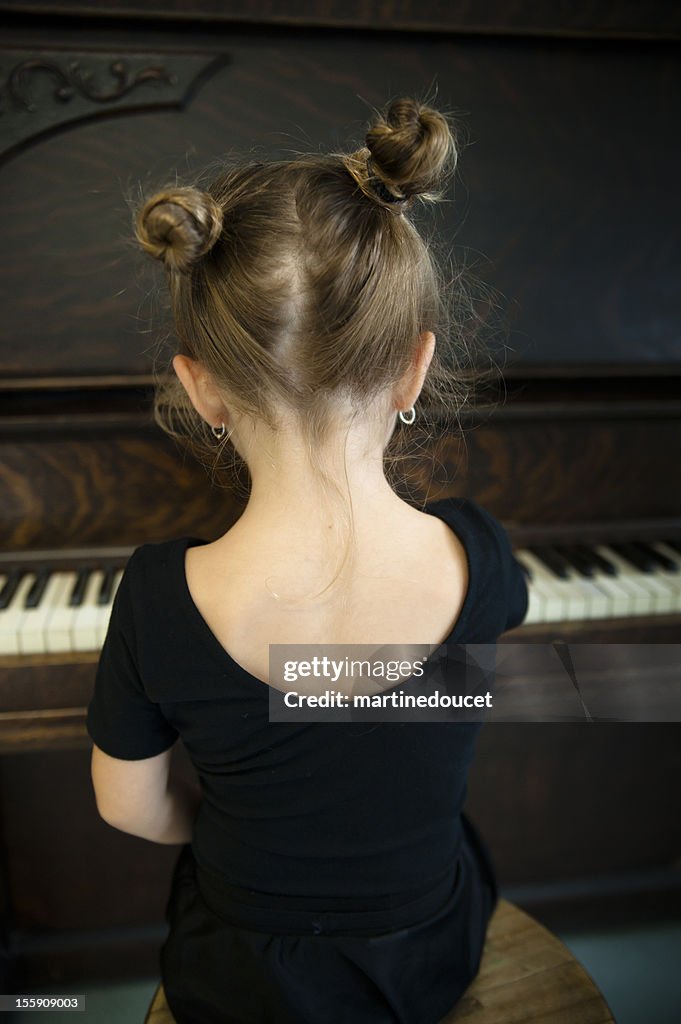 Rückseite kleine ballerina spielt Klavier.