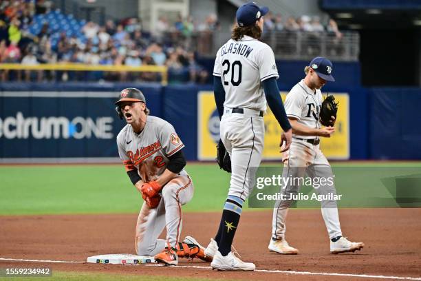 Gunnar Henderson of the Baltimore Orioles reacts after arriving safe at third base after a throwing error by Randy Arozarena to Tyler Glasnow of the...
