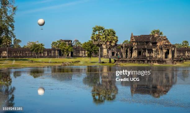 Sightseeing hot air balloon rises up above the famed ancient temple of Angkor Wat in Cambodia.