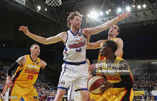 Jonny Flynn of the Tigers controls the ball as Luke Schenscher of the 36ers defends during the NBL match between the Melbourne Tigers and the...