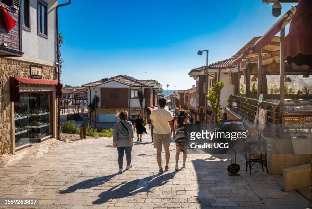 Tourists walk in Liman St in Side Old Town in Antalya Province, Turkey. Side is the site of an ancient Roman city and a popular cultural and tourist...
