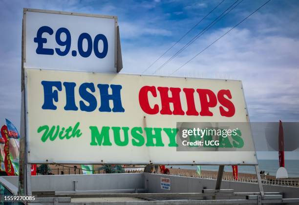 Large sign advertising fish and chips on Brighton beach, East Sussex, UK. Fish and chips is a national dish in the UK and always associated with the...