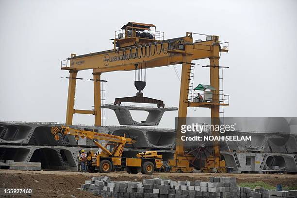 Indian labourers work at the casting yard of L and T construction making segments for the Hyderabad Metro Rail in Hyderabad on November 9, 2012. The...