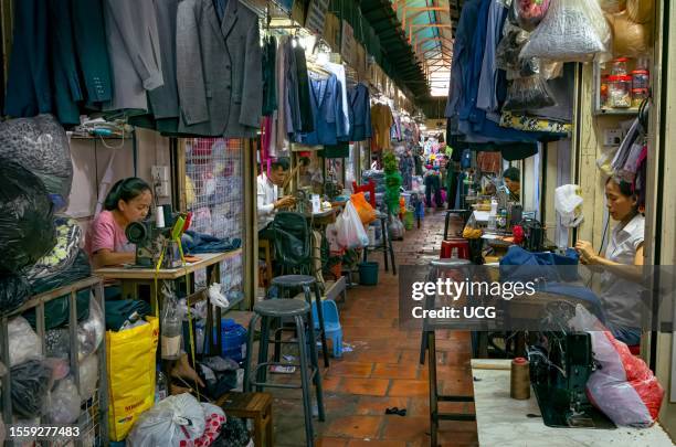Tailors and seamstresses work in a passageway inside the Russian Market in Phnom Penh, Cambodia.