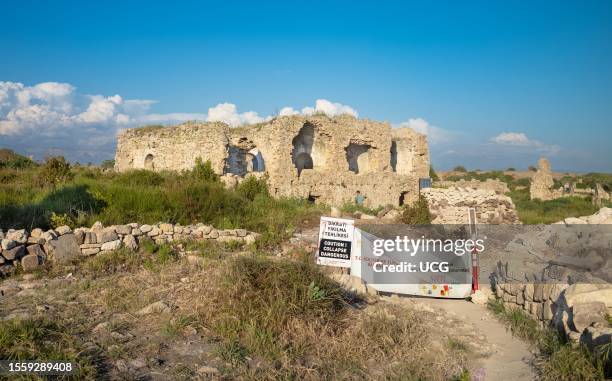 Sign warns people of possible building collapses at the Byzantine hospital and other unexcavated ruins at the ancient Roman city at Side in Antalya...