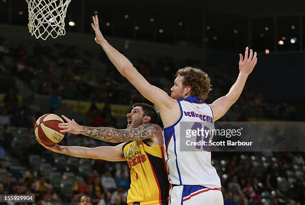 Nate Tomlinson of the Tigers shoots the ball as Luke Schenscher of the 36ers defends during the NBL match between the Melbourne Tigers and the...