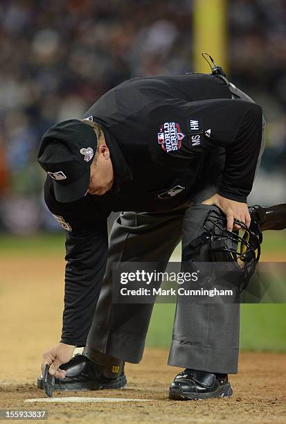 Major League umpire Fieldin Culbreth cleans off home plate during Game Three of the World Series between the San Francisco Giants and the Detroit...