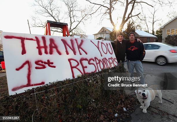 Residents Paul and Donald Zezulinski and their dog "Plywood" of Island Park show their appreciation to first responders during their clean up efforts...