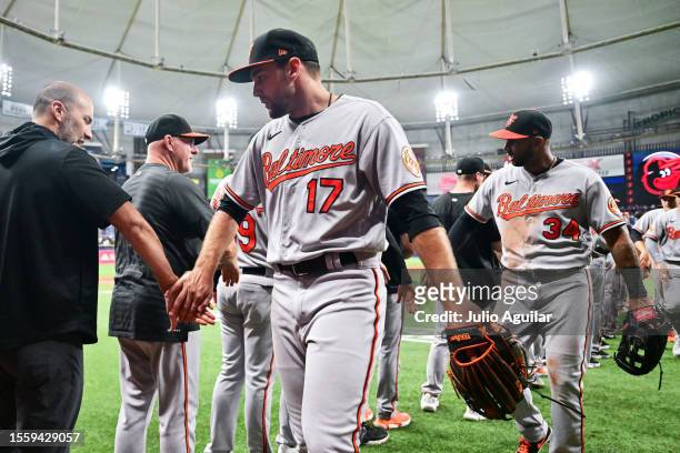 Colton Cowser and Aaron Hicks of the Baltimore Orioles celebrate with teammates after defeating the Tampa Bay Rays 4-3 at Tropicana Field on July 20,...