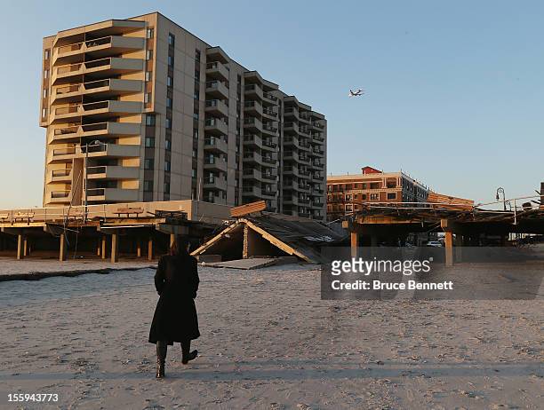 Resident walks past a destroyed section of the boardwalk at the base of Lincoln Boulevard as Long Islanders continue their clean up efforts in the...