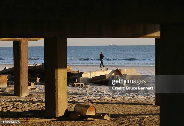 Man walks past a destroyed section of the boardwalk at the base of Lincoln Boulevard as Long Islanders continue their clean up efforts in the...