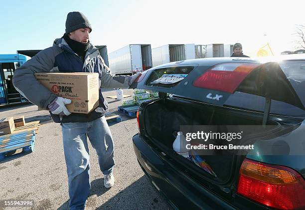 Workers distribute essential goods to residents at a site maintained by the Town of Hempstead in cooperation with FEMA at Oceanside Park during in...