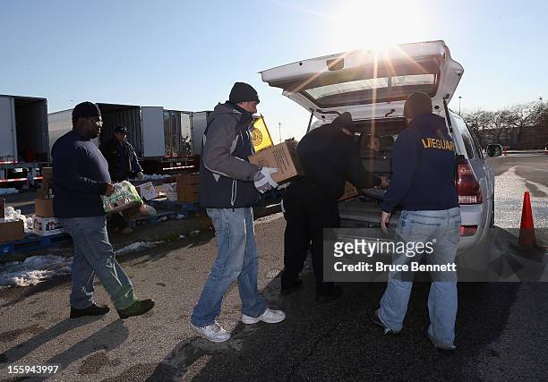 Workers distribute essential goods to residents at a site maintained by the Town of Hempstead in cooperation with FEMA at Oceanside Park during in...
