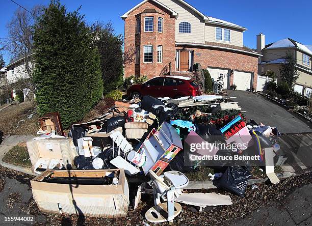 The street in front of a home on Wynsum Lane is littered with contents of a flooded home in the aftermath of Superstorm Sandy on November 9, 2012 in...