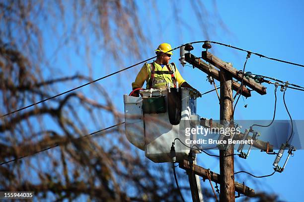 Worker positions himself to repair electrical lines as Long Islanders continue their clean up efforts in the aftermath of Superstorm Sandy on...