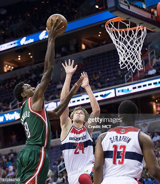 Milwaukee Bucks center Larry Sanders scores over Washington Wizards small forward Jan Vesely and power forward Kevin Seraphin during the first half...