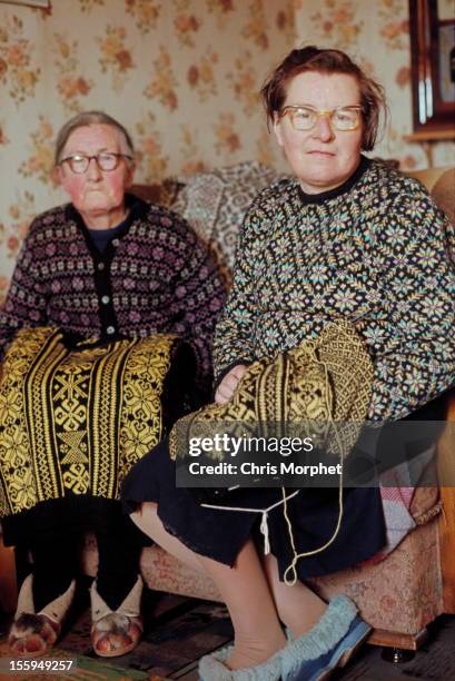 1st JUNE: Two elderly women wearing Fair Isle jumpers pose while knitting in the living room of a cottage on one of the Shetland Islands in June 1970.