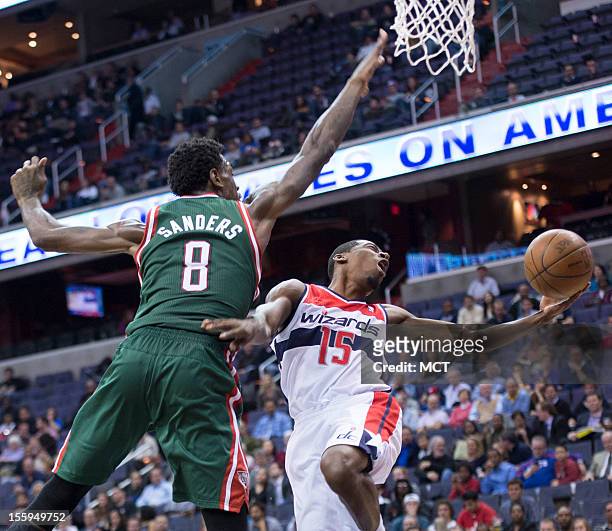 Washington Wizards shooting guard Jordan Crawford looses control of the ball on his way up for a shot while being guarded by Milwaukee Bucks center...