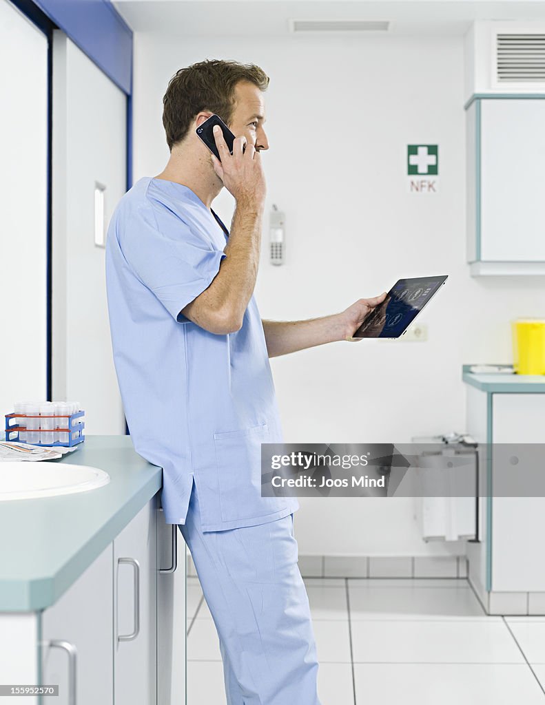 Surgeon using digital tablet and smart phone