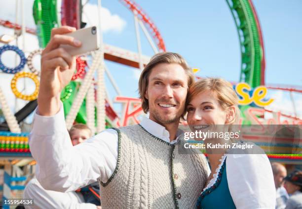 couple using smartphone to take a self-portrait - 十月啤酒節 個照片及圖片檔