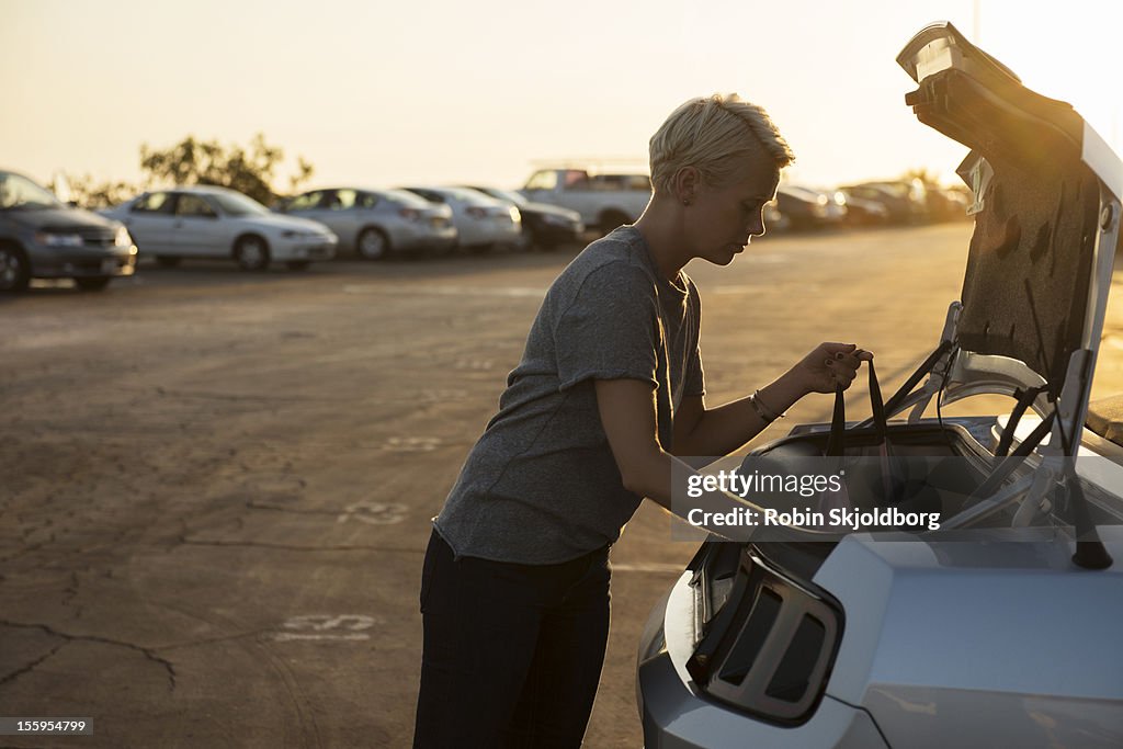 Woman looking into trunk of car