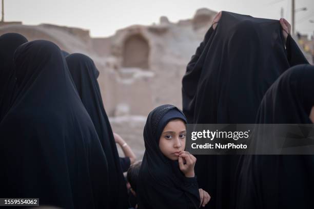 Veiled young Iranian girl looks on while taking part in the Zaar Khak ritual ceremony to mark Tasoua, which is a day before Ashura, in the historical...