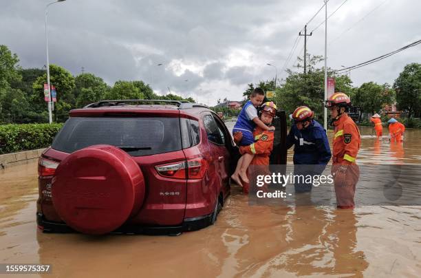 Rescuers evacuate residents in a flooded area after Typhoon Doksuri landfall in Quanzhou, in China's eastern Fujian province on July 28, 2023. /...