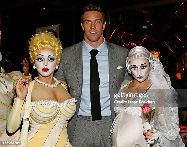 Arizona Cardinals linebacker Stewart Bradley appears with "Zarkana by Cirque du Soleil" characters at the reception for the Las Vegas premiere of...