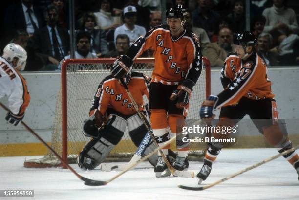Mike Gartner of the Wales Conference and the Washington Capitals shoots the puck as Paul Coffey and Jari Kurri of the Campbell Conference and the...