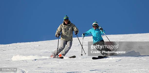 雄および雌の詰まったパウダースノーでのスキー - ski new zealand ストックフォトと画像