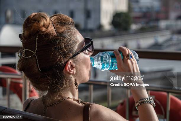 Woman seen drinking water in an open area of the ferry. On a summer day, the temperature in Istanbul soared to a sweltering 40 degrees Celsius.
