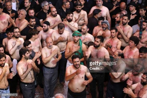 Shiite Muslims beat their chests during the mourning ritual ceremony of Ashura, in Tehran on July 28, 2023. Ashura is one of the most important...