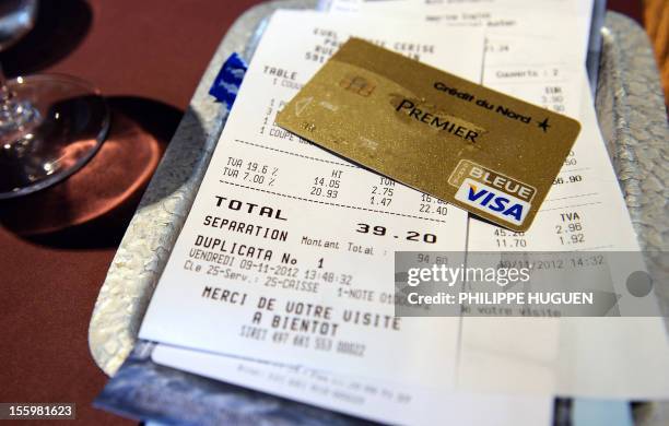 Picture taken on November 10, 2012 in a restaurant in Lille shows a credit card set up on a bill with the 19,60 percent value added tax , and the 7...