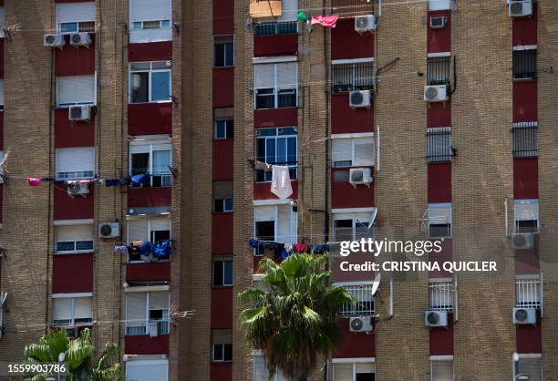 Air conditioners hang on facade of a residential building in Seville, southern Spain, on July 28, 2023.