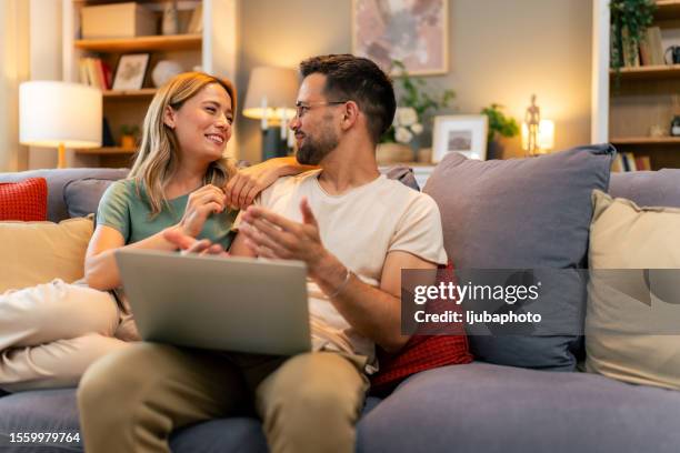 couple paying bills online, calculate expenses at home - duas pessoas imagens e fotografias de stock