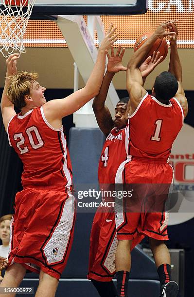 Youngstown State forward Bobby Hain , guard Shawn Amiker and guard Blake Allen converge on a rebound in the second half against George Washington...