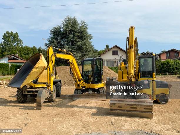 earth-moving machinery on a construction site - maquinaria de construcción fotografías e imágenes de stock