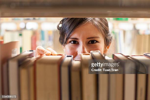woman grabbing book at bookstore - bookstore ストックフォトと画像